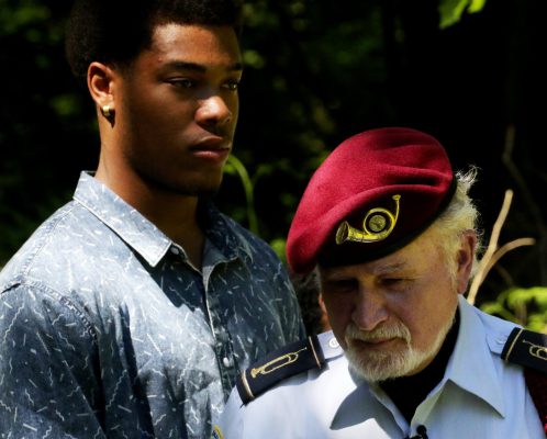 Cleveland High senior Jeffrey Beasley and Bernie Moskowitz, president of the alumni association, listen to speakers before the conclusion of the ceremony honoring fallen alums from the school. Beasley is planning on a career in the navy. (Alan Berner/The Seattle Times)